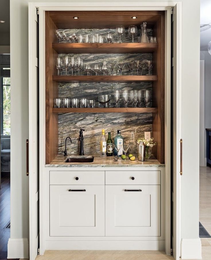 an open cabinet filled with glasses and bottles