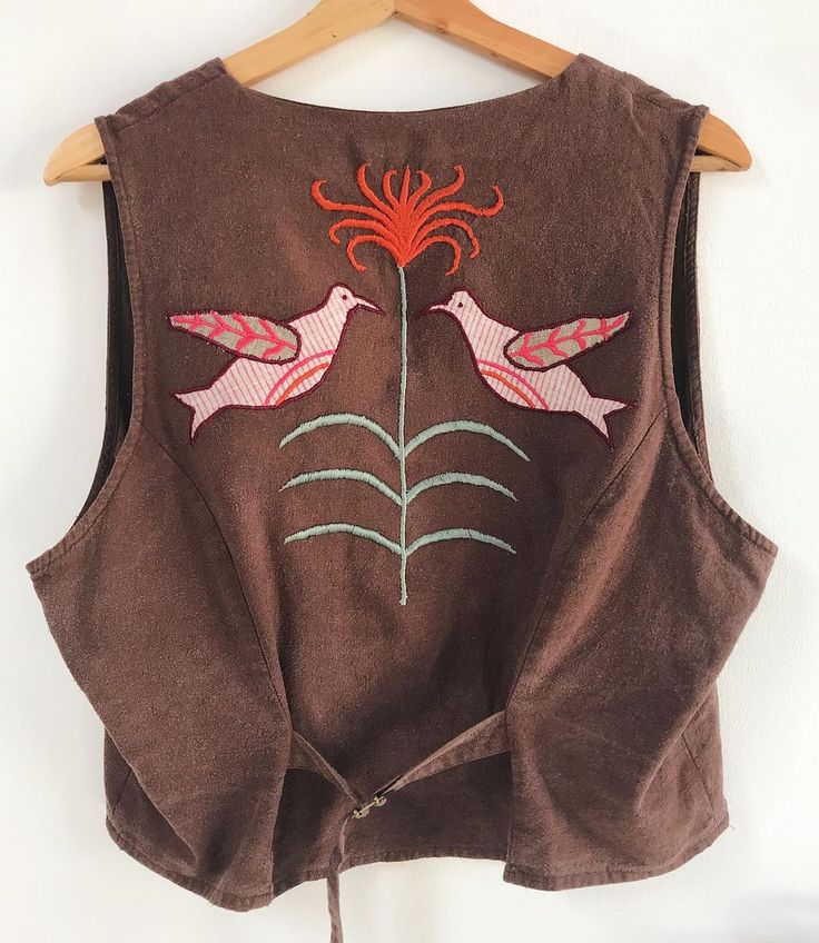 a brown vest with two birds on it