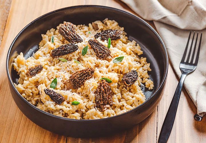 a bowl filled with rice and raisins on top of a wooden table