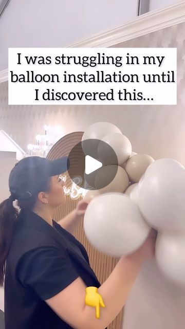 a woman in black shirt holding white balloons