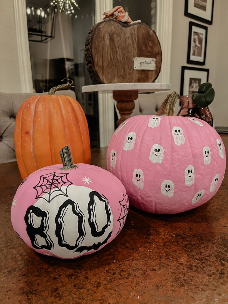 two painted pumpkins sitting on top of a table