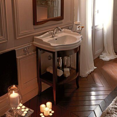 a bathroom with a sink, mirror and candles on the floor