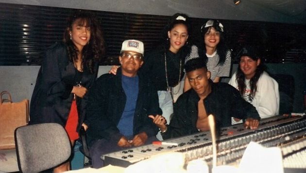 a group of people posing in front of a mixing desk