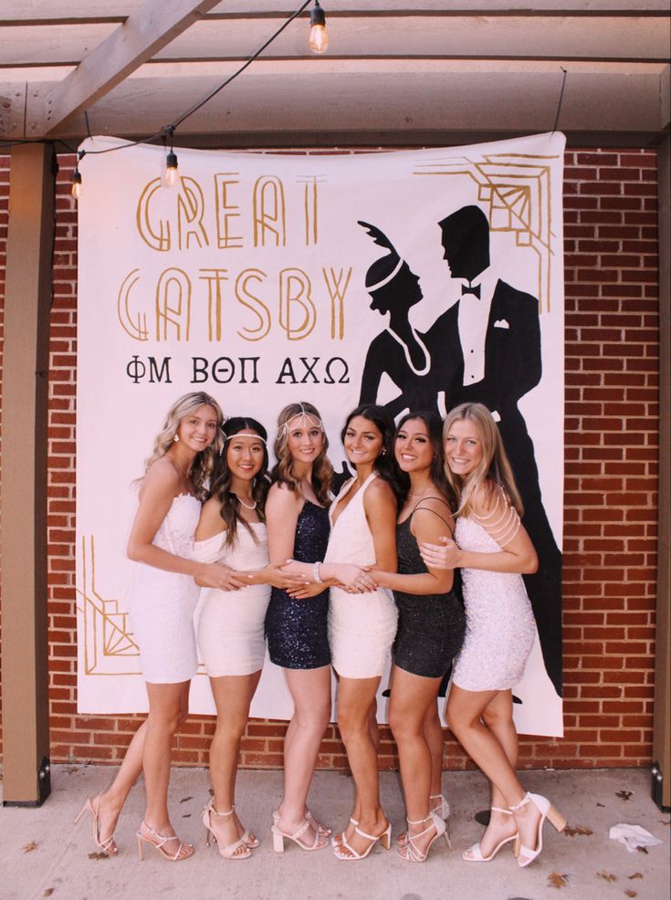 a group of young women standing next to each other in front of a sign that says great gatsby