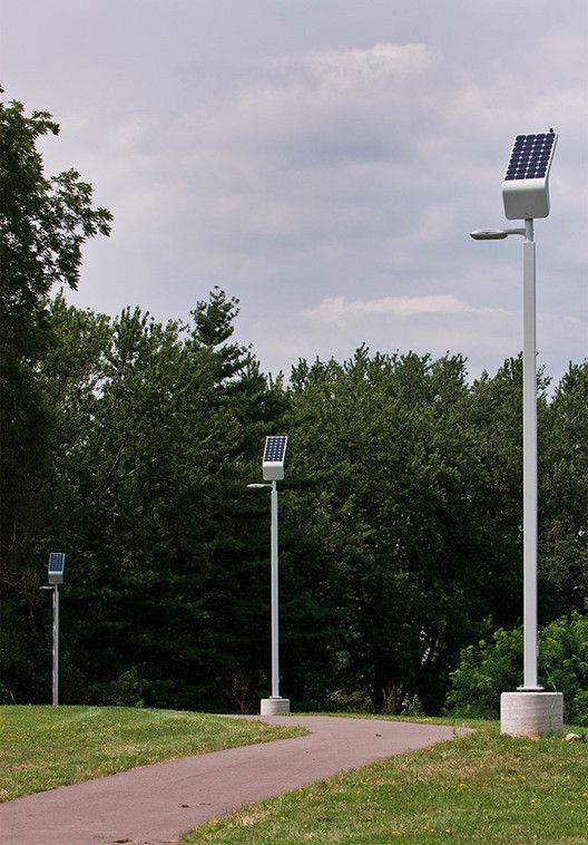 two street lights on poles next to a path