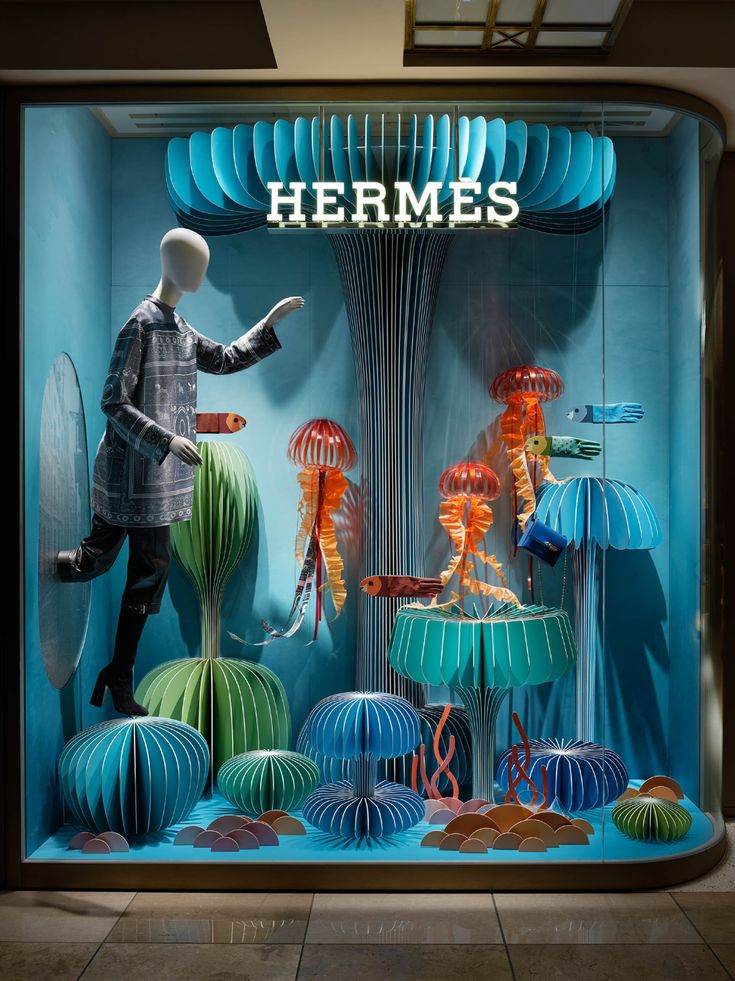 a window display with blue and green paper lanterns, lamps and mannequins