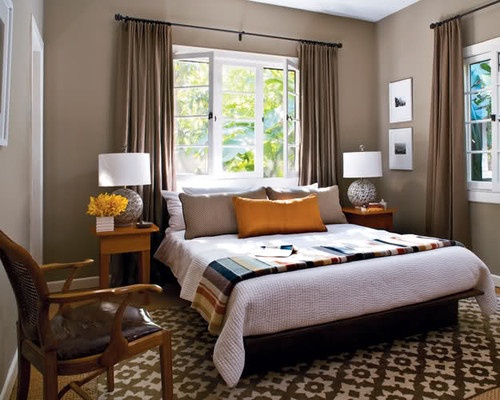 a bed room with a neatly made bed and two lamps on either side of the bed