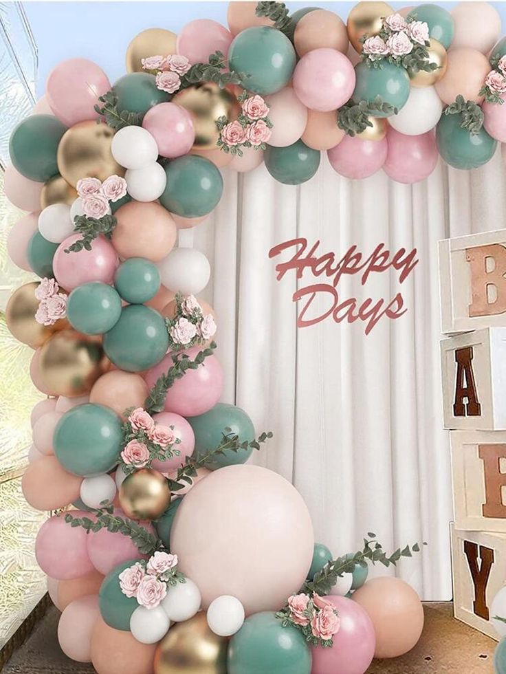 the balloon arch is decorated with flowers and balloons for a happy birthday party in pastel colors