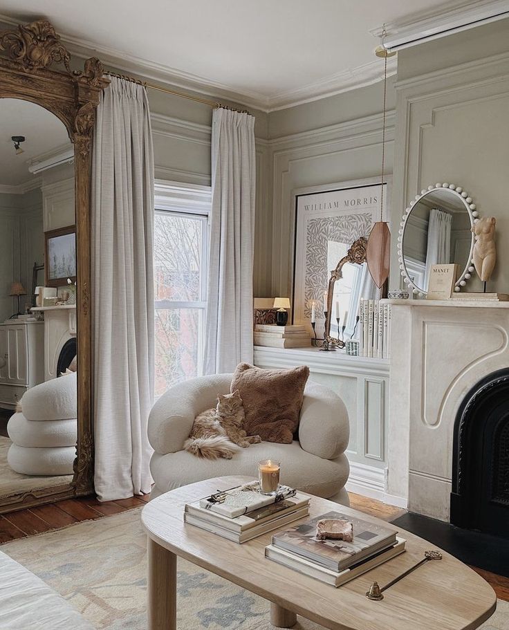 a living room filled with furniture and a fire place in front of a mirror on the wall