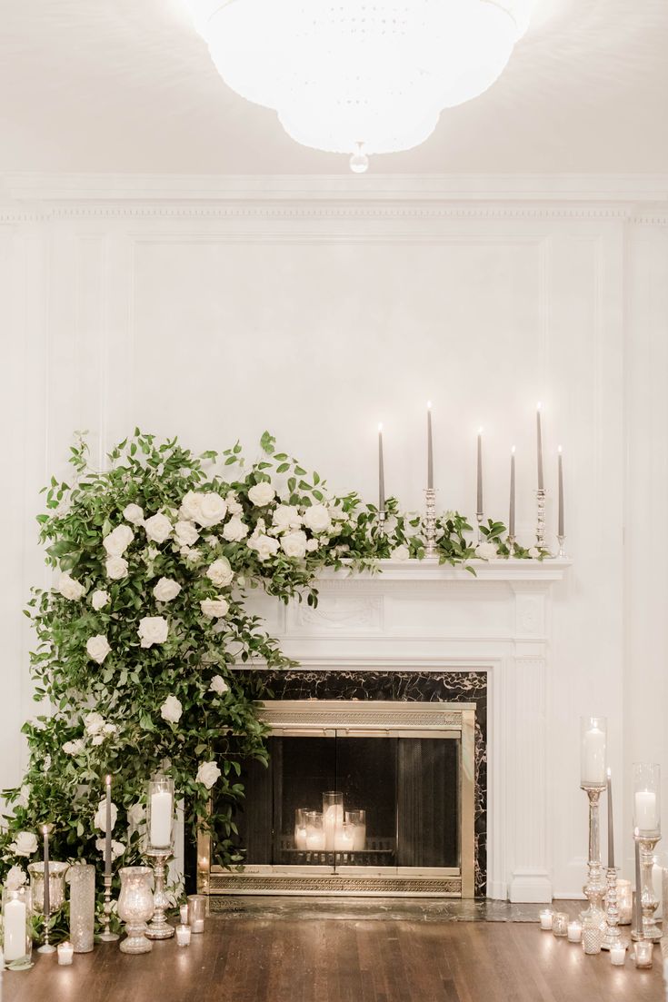 the fireplace is decorated with candles and flowers