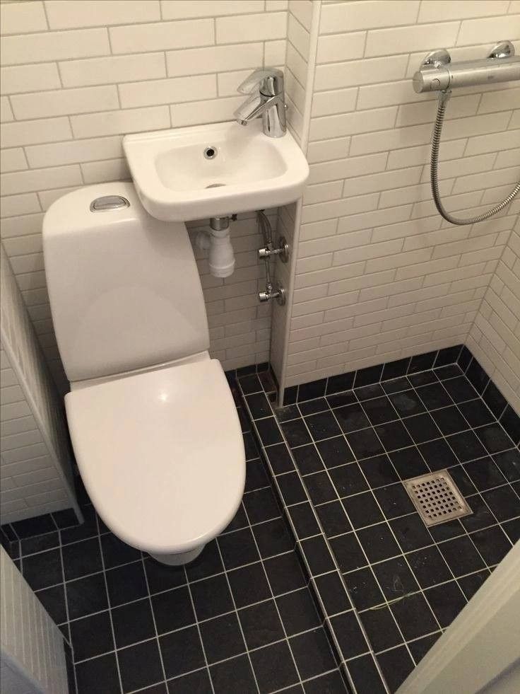 a white toilet sitting next to a sink in a bathroom under a faucet