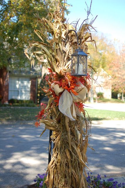 a lamp post decorated with dried corn stalks and fall foliage for the front yard or patio