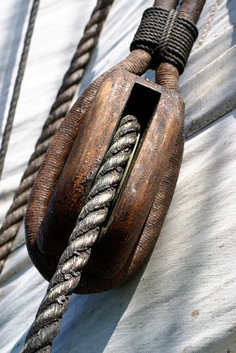 the rope is attached to the sailboat's rig and it looks like an old boat