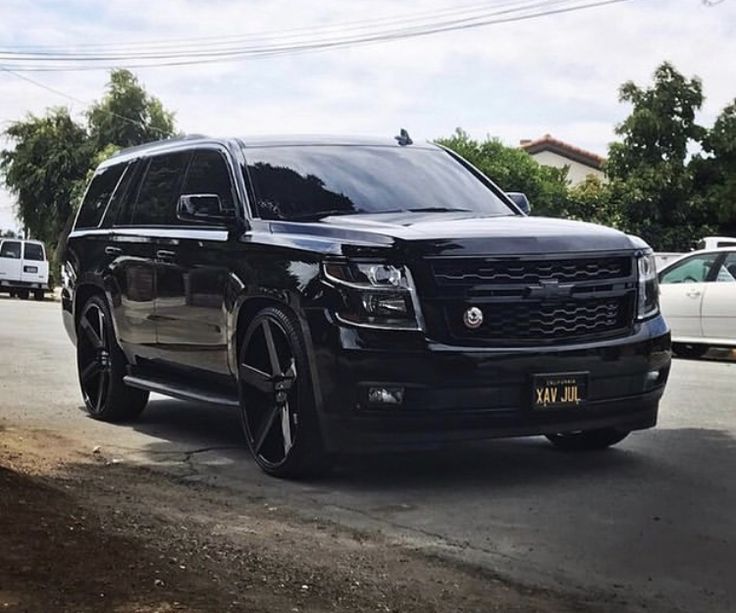 the black suv is parked on the side of the road