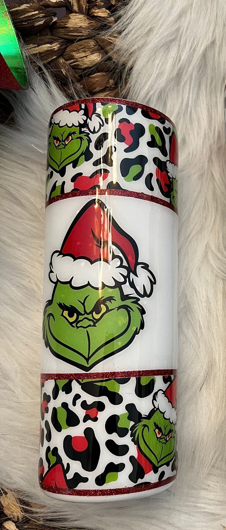 the grino christmas mug has been decorated with santa's hat and leopard print