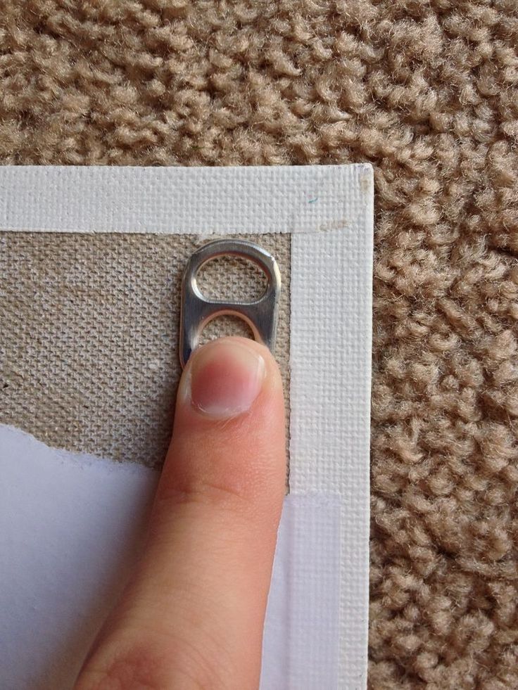 a person's finger is on the edge of a piece of fabric with a hole in it