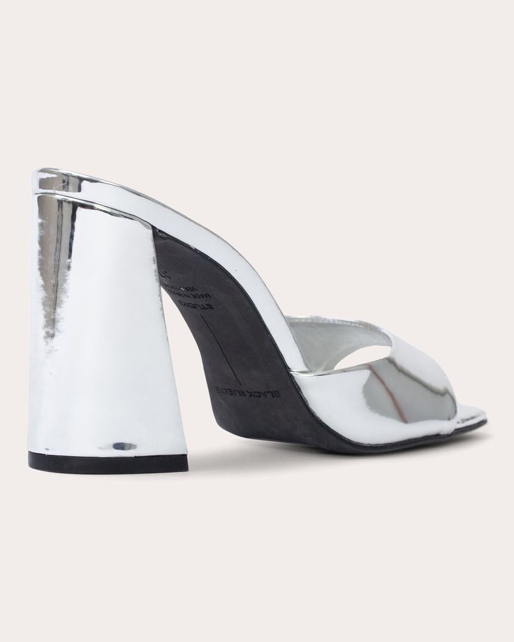 A modern take on traditional mules, Daisy is crafted from metallic leather for a mirrored effect. The block heel and squared toe team up to create architectural appeal. Slip-on Squared toe Upper: 100% mirrored metallic leather Lining: 100% leather Outsole: 100% leather Spot clean Made in Brazil Size & Fit Heel height: 3.94in (100mm) Fits true to size | Black Suede Studio Women's Daisy Metallic Mule in Silver Mirror Metallic Leather Size 35 Designer Metallic Leather Heels, Silver Metallic Leather Party Heels, Metallic Leather High Heel Mules, Luxury Silver Mules With Sculpted Heel, Luxury Metallic Silver Leather Heels, Silver Mirror, Made In Brazil, Silver Mirrors, Metallic Leather