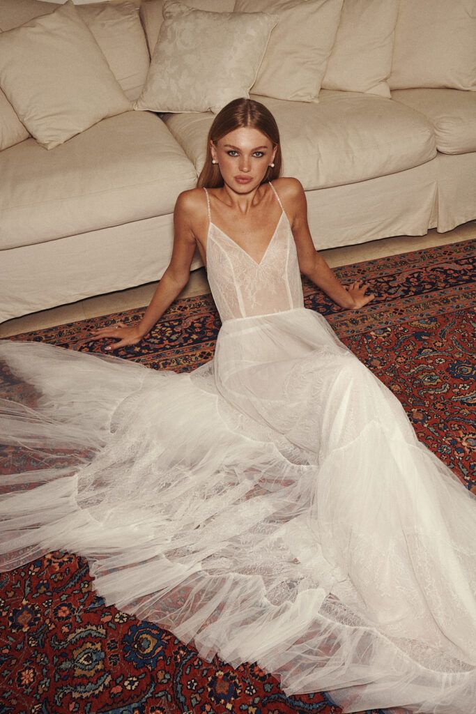 a woman sitting on the floor in a white dress