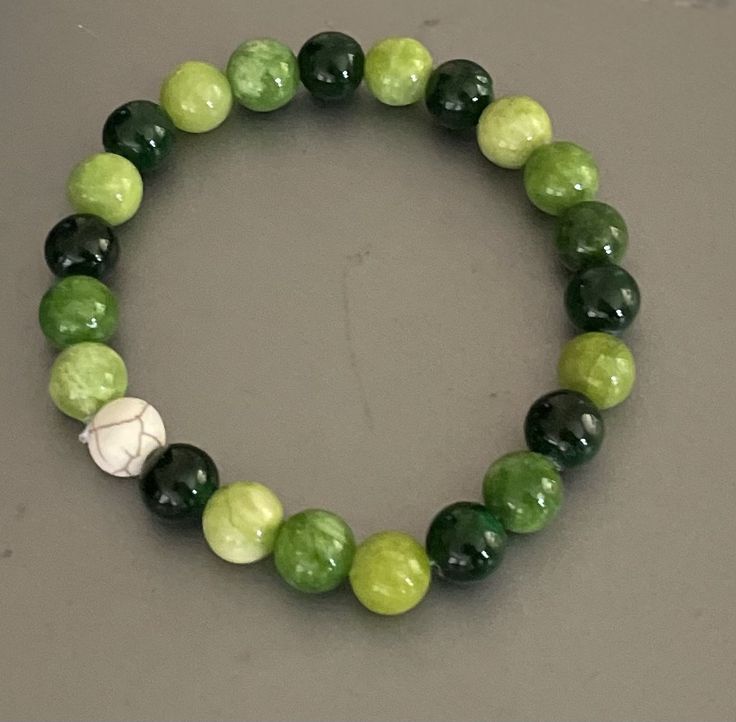 Multi-colored green stone beaded bracelet Wrist size: 20 cm Bead size: 8 mm Emerald green, lime green, & light green aventurine beads with a white howlite bead for accent purposes. Specifically for a small handed; small wrist individual; doesn't stretch Green Stretch Bracelet With Natural Stones, Casual Green Gemstone Bead Jewelry, Green Onyx Round Beads Bracelets, Green Onyx Round Beads Bracelet, Casual Green Gemstone Beads Jewelry, Casual Green Stretch Bracelet With Natural Stones, Green Spiritual Stretch Bracelet For Healing, Green Aventurine Stretch Bracelet With Natural Stones, Green Onyx Beaded Bracelets As Gift