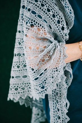 the woman is wearing a lacy shawl with her hand on her hip and holding onto her wrist