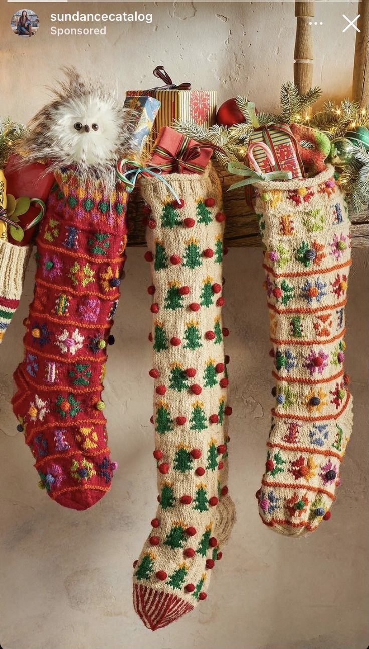 two christmas stockings hanging from a mantle with presents on it and a cat in the stocking