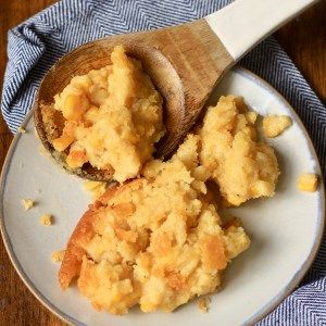 two pieces of bread on a plate with a wooden spoon