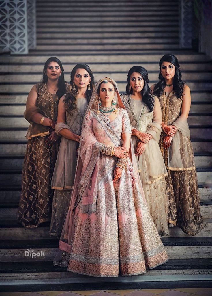 a bride and her bridals posing for a photo in front of some stairs