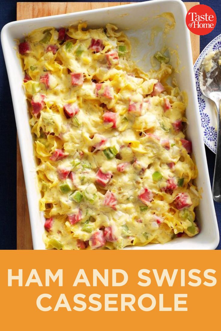 ham and swiss casserole in a white dish on a wooden cutting board with spoons