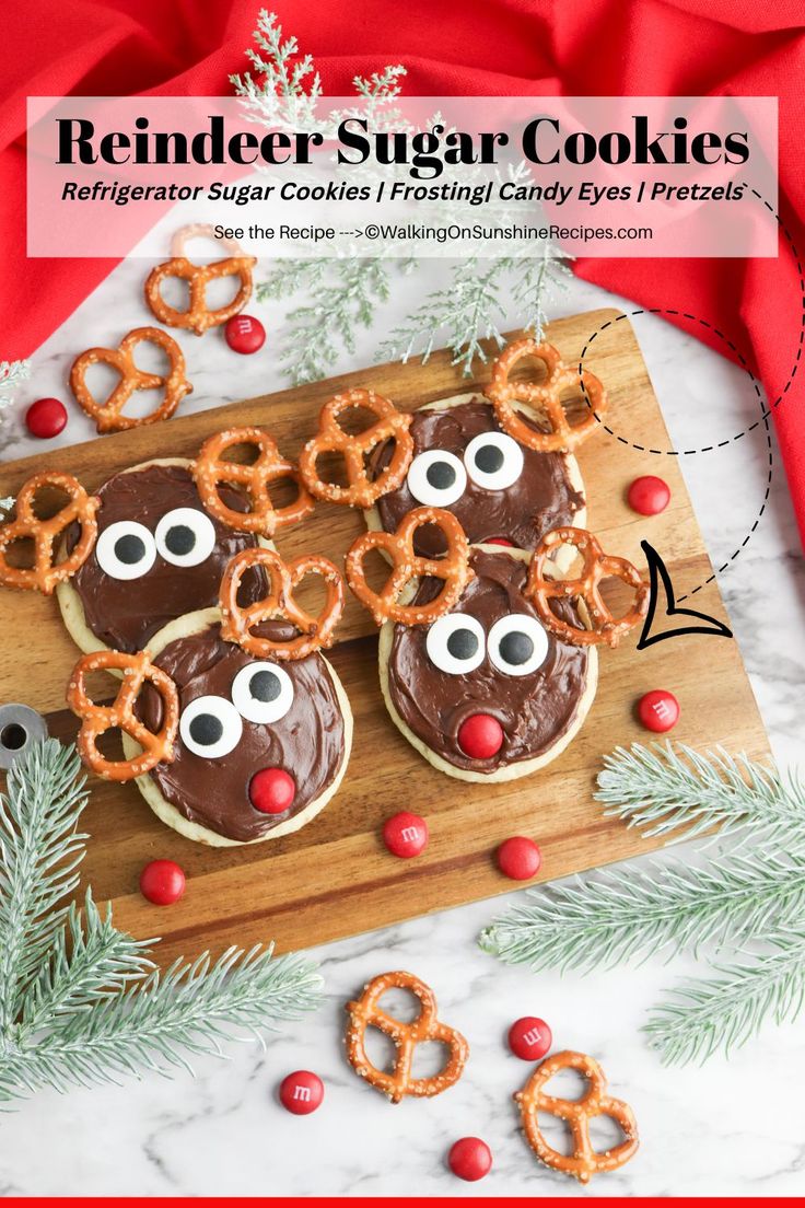 reindeer sugar cookies with chocolate frosting and pretzel eyes on a wooden board