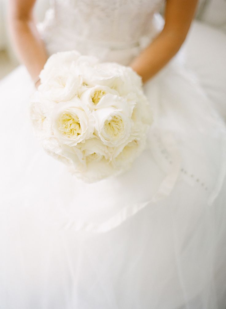 a bride holding a bouquet of white flowers