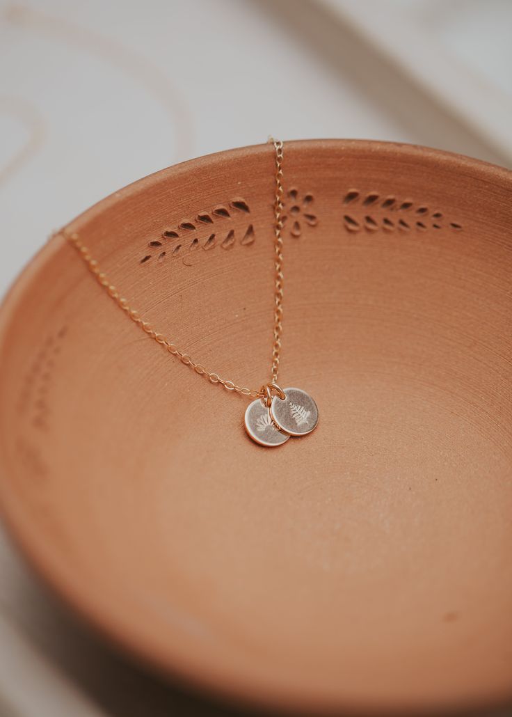 Our sweet, tiny dot stamped with one of our little symbol stamps and/or initials. A solid 9mm disc is hand-stamped and attached to a 16" or 18” delicate cable chain. Digits, Initials & Symbols available - see the photo chart. Available in 14kt Gold Fill + Sterling Silver. To ensure pendants remain on the delicate chain, pendants are intentionally designed to not slide on and off the chain. If you need assistance adding a pendant to a Tiny Dot Necklace you already own, please email us at hello@he Dainty 14k Gold Filled Hand Stamped Necklace, Dainty Hand Stamped 14k Gold Necklace, Dainty Hand Stamped Round Disc Necklaces, Minimalist 14k Gold Hand Stamped Charm Necklace, Dainty Hand Stamped 14k Gold Charm Necklaces, Dainty Hand Stamped Round Disc Necklace, Minimalist Hand Stamped 14k Gold Filled Necklace, Minimalist Hand Stamped Gold Necklace, Dainty Stamped Charm Necklaces For Everyday