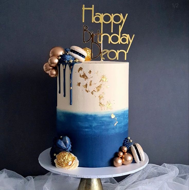 a blue and white birthday cake with gold decorations