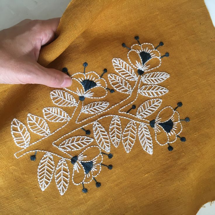 someone is stitching something on top of a piece of cloth that has been embroidered onto