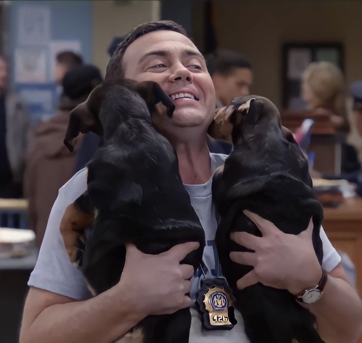 a man holding two dogs in his arms