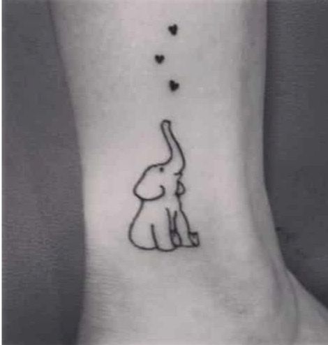 a small elephant with hearts flying from its trunk on the side of the ankle tattoo