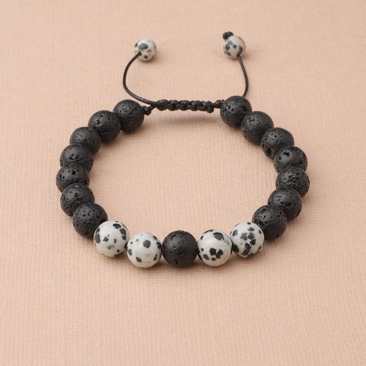 This handmade wax cord bracelet features Dalmatian Jasper and lava stones. Dalmation Jasper is a stone of action, calming the overactive mind while also promoting motivation and enthusiasm. It is known to encourage a child-like joy and energy, as well as reflection and self-examination. Lava Beads are made from Natural Volcanic Basalt. The lava stones acts as a sponge-like carrier as it soaks up your oils and retains them in the core of the Bead. Casual Braided Bracelets With 8mm Beads As Gift, Casual Braided Bracelets With 8mm Beads For Gifts, Casual Adjustable Lava Stone Jewelry, Casual Adjustable Lava Stone Beaded Bracelets, Casual Adjustable Bracelets For Meditation, Handmade Adjustable Lava Stone Beaded Bracelets, Adjustable Lava Stone Beaded Bracelets, Adjustable Lava Stone Beaded Bracelets With Natural Stones, Casual Everyday Lava Stone Beaded Bracelets