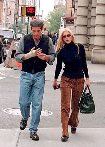 the man and woman are walking down the street with their purses in each hand