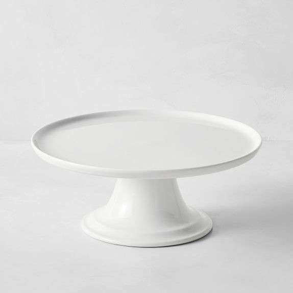 a white cake plate sitting on top of a table