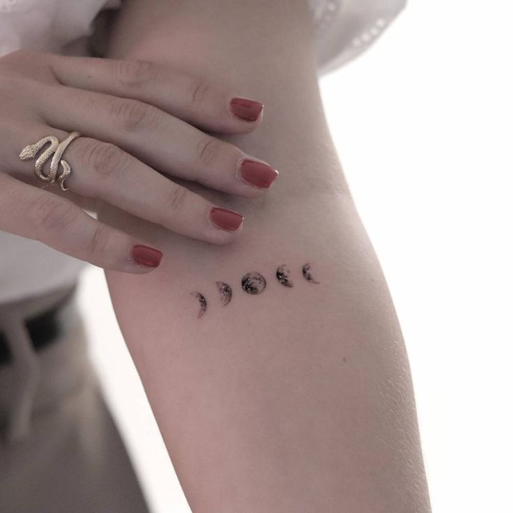 a woman's arm with the word love written on it and five different moon phases