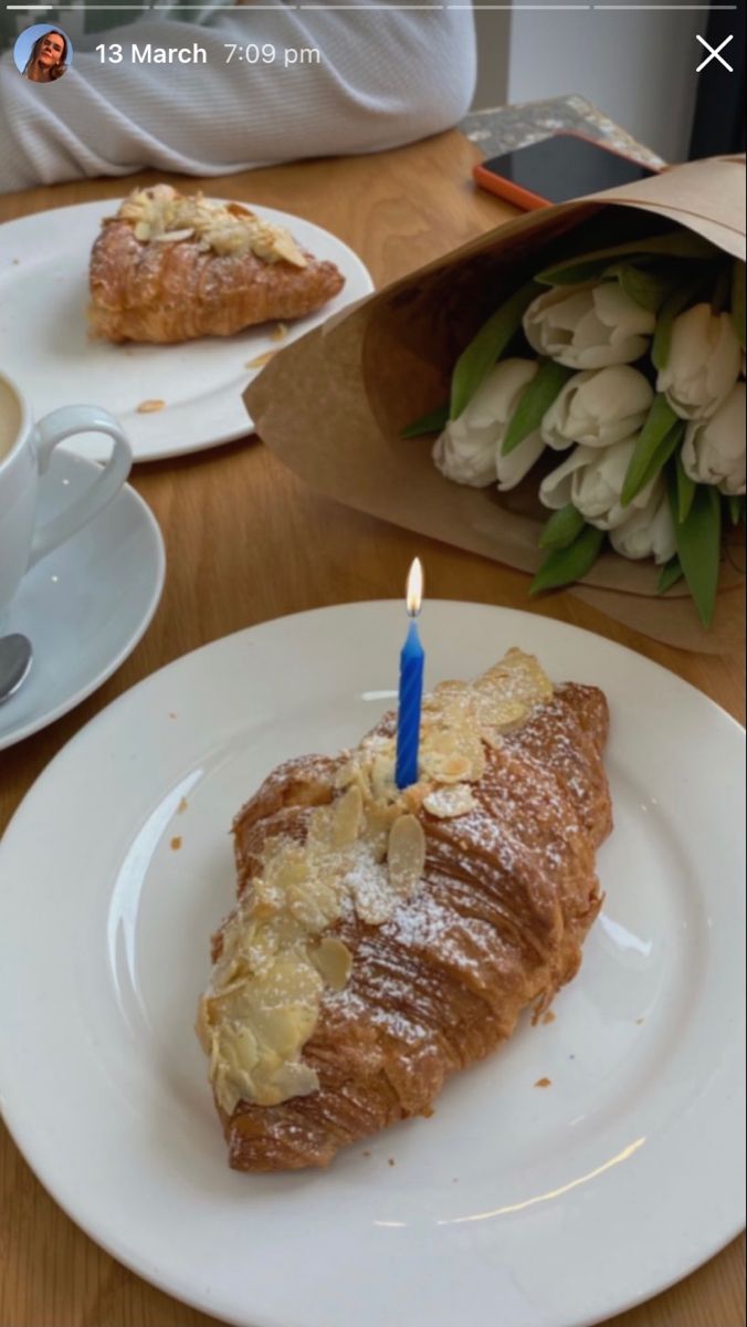 a piece of bread on a plate with a lit candle