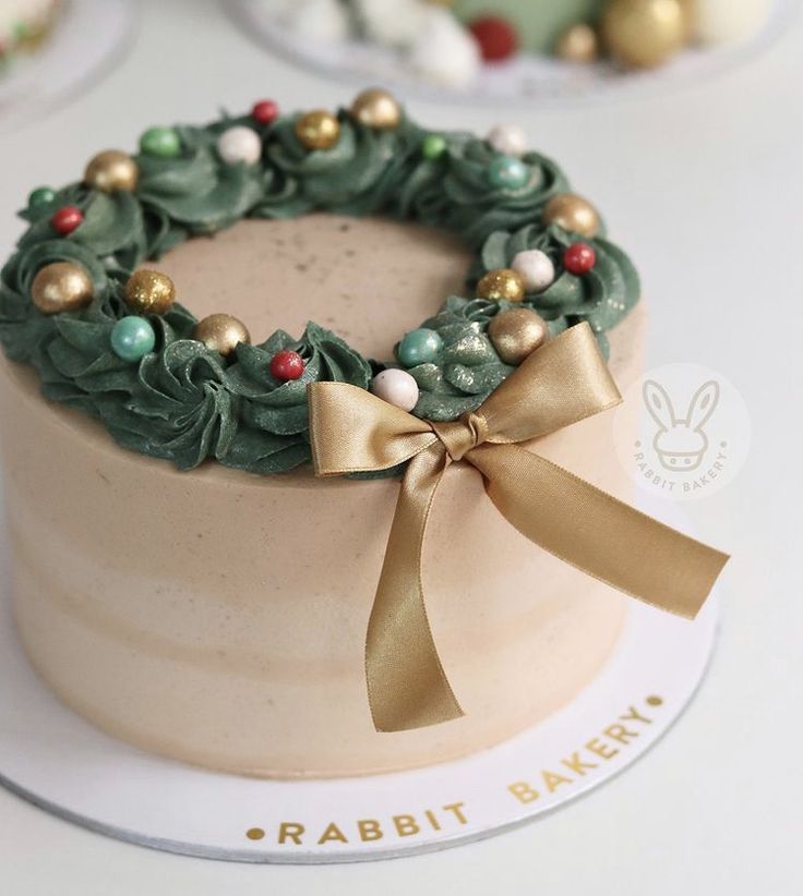 a cake decorated with green and gold decorations on top of a white tablecloth covered plate