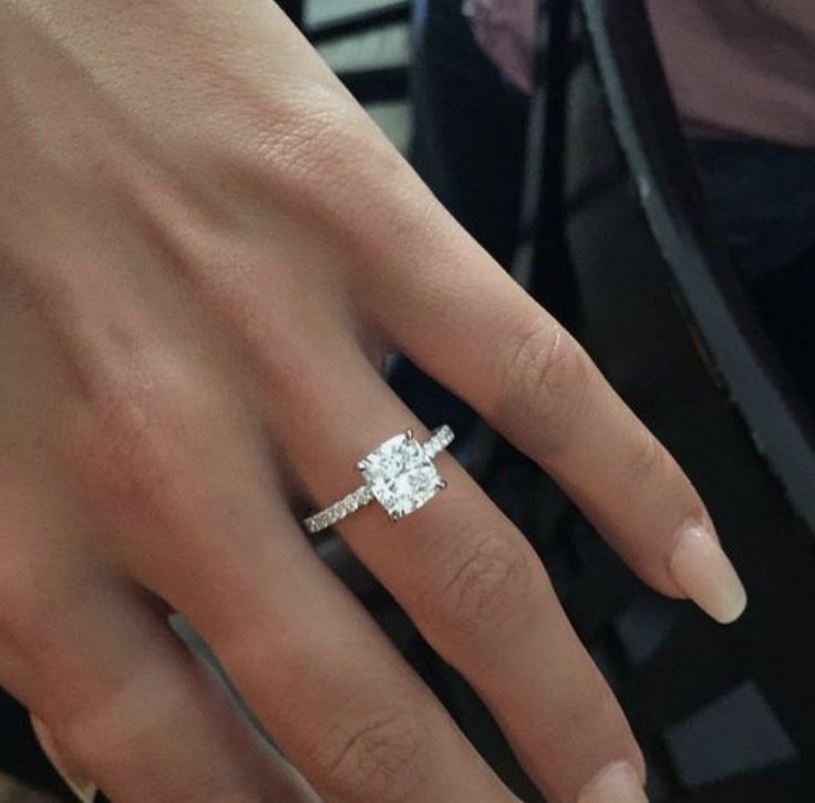 a woman's hand with a diamond ring on it