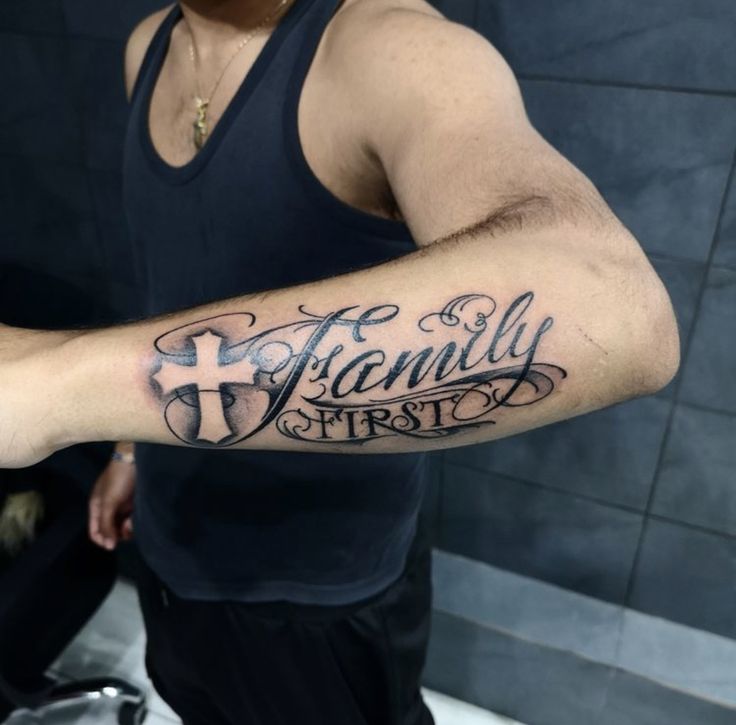 a man with a tattoo on his arm that reads family first and has a cross