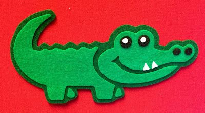 a paper cut out of a crocodile with its mouth open and eyes wide open on a red background