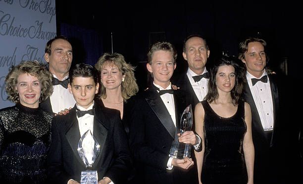 a group of people in tuxedos posing for a photo at an awards ceremony