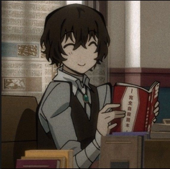 an anime character is reading a book while sitting at a desk in front of a computer