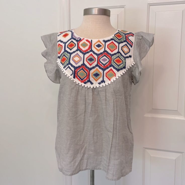 New With Tags! Thml Gray With Multicolored Embroidered Bib Flutter Sleeves Embroidery Detail On Back As Well! 100% Cotton Size Medium Approx Measurements Chest (Pit To Pit) 18.5” Inseam (Pit To Hem) 15.5” Length (Top Of Shoulder To Hem) 24.5” * Selling Other Thml Bundle And Save Sleeveless Cotton Top With Embroidery And Ruffles, Sleeveless Patchwork Tops For Beach, Sleeveless Patchwork Beach Tops, Sleeveless Patchwork Vacation Tops, Sleeveless Patchwork Top For Vacation, Summer Embroidered Top With Flutter Sleeves, Summer Embroidered Blouse With Flutter Sleeves, Summer Flutter Sleeve Embroidered Top, Sleeveless Tops With Multicolor Embroidery For Vacation