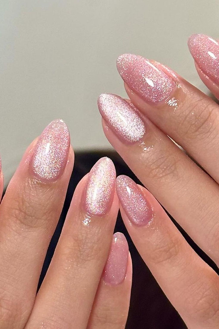 Radiant Elegance: Shimmering Pink Cat Eye Almond Nails exuding sophistication and charm 💖✨ // Photo Credit: Instagram @pallyynails Pink Sparkle Almond Acrylic Nails, Nails That Fit With Everything, New Year Pink Nails, Pink Nails Magnetic, All Pink Glitter Nails, Nails Pink Cat Eye, Magnet Nails Pink, Light Pink Magnetic Nails, Magnetic Almond Nails