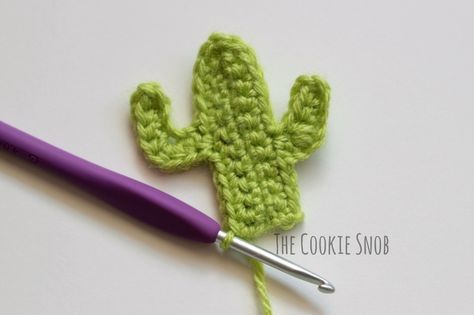 the crochet cactus is next to a purple crochet hook