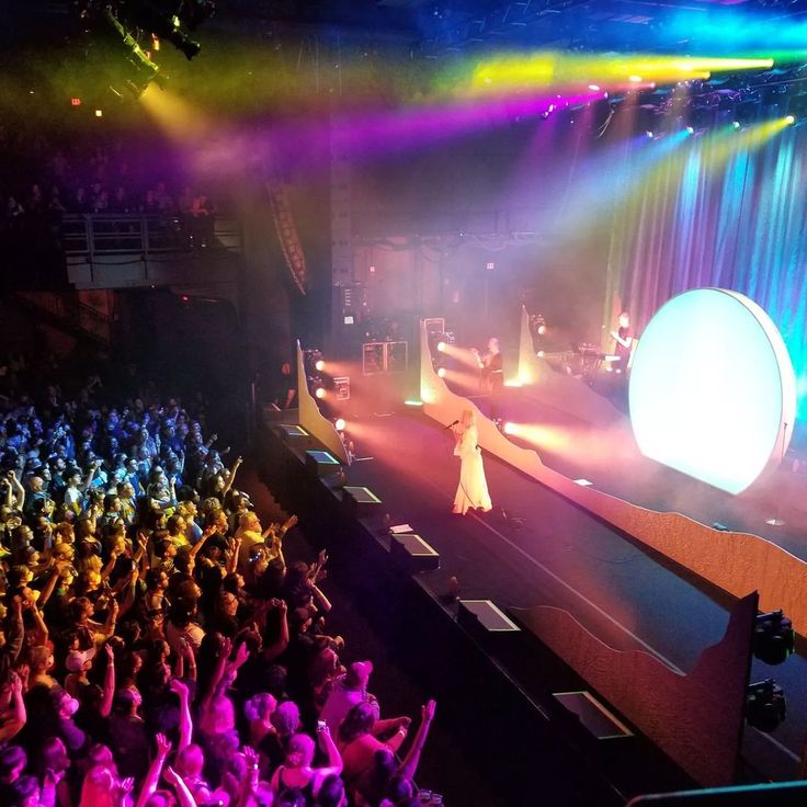 a woman standing on top of a stage in front of a large group of people